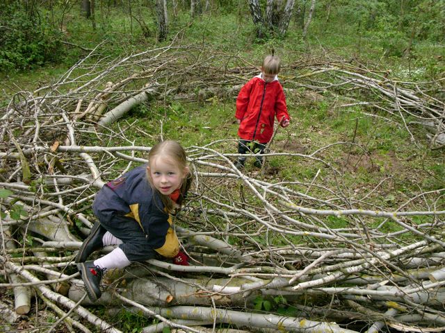 zwei Kinder spielen im Wald mit Ästen
